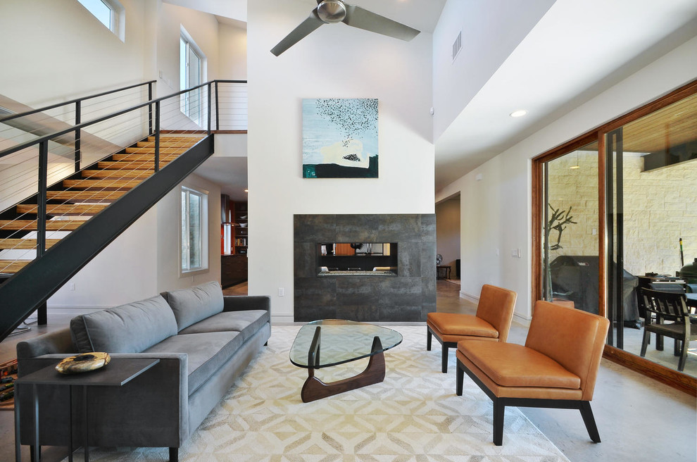 Repräsentatives Modernes Wohnzimmer mit weißer Wandfarbe, Betonboden, Gaskamin und Kaminumrandung aus Beton in Austin