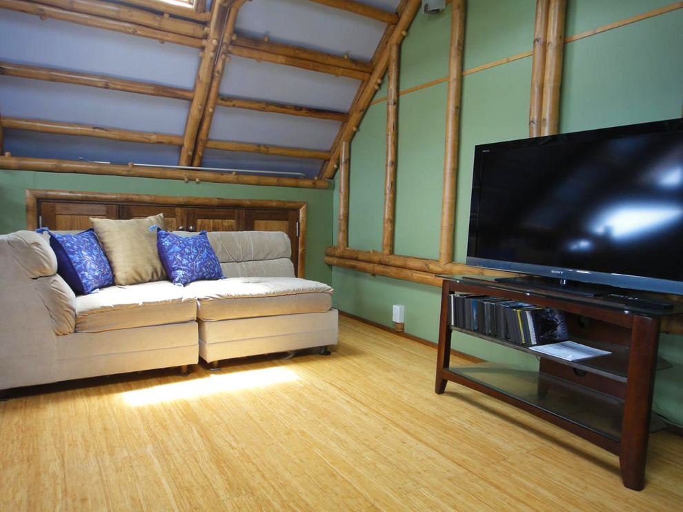 Imagen de salón exótico con paredes verdes y suelo de bambú