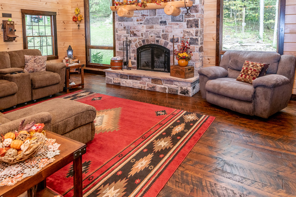Rustic formal mezzanine living room in Other with medium hardwood flooring, a standard fireplace, a stone fireplace surround and brown floors.