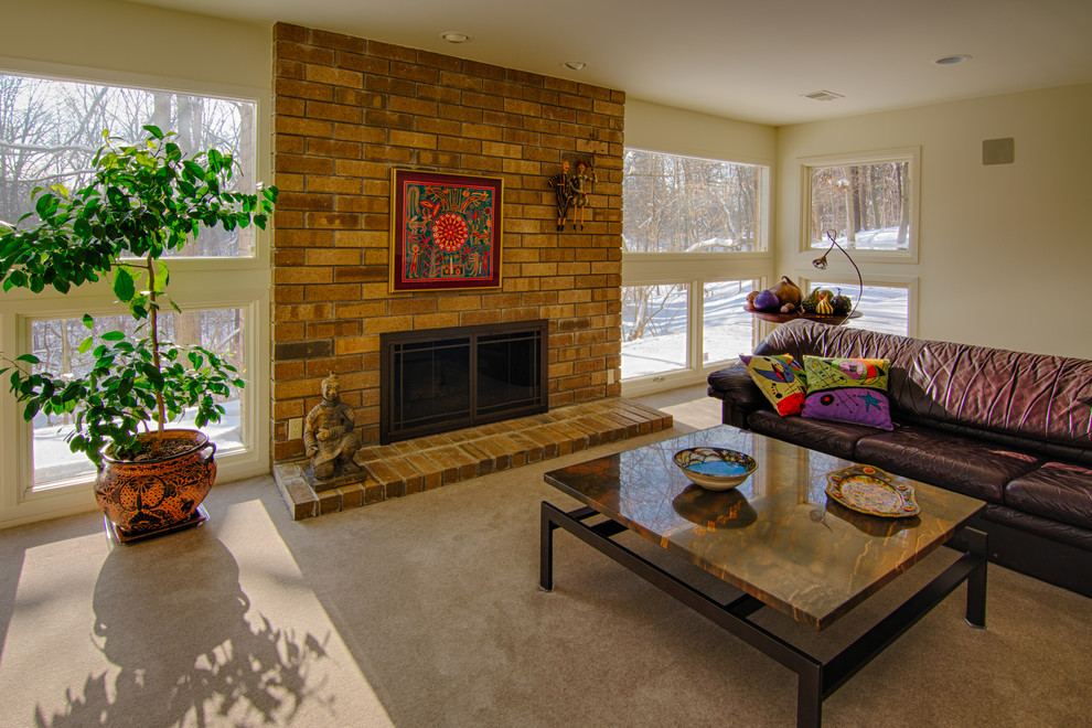 Photo of a medium sized contemporary formal enclosed living room in Detroit with white walls, carpet, a standard fireplace, a brick fireplace surround and no tv.