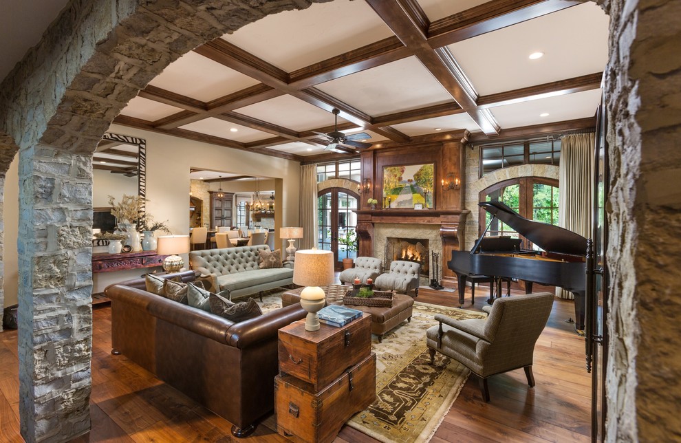 Example of a large classic open concept medium tone wood floor living room design in Milwaukee with a music area, beige walls, a standard fireplace, a stone fireplace and a wall-mounted tv