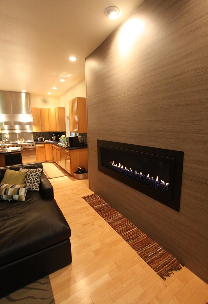 На фото: гостиная комната в стиле фьюжн с горизонтальным камином и фасадом камина из плитки с