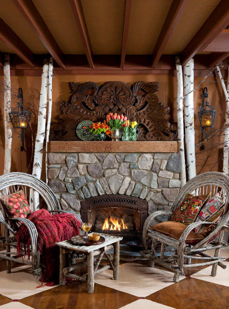 Imagen de salón abierto rural de tamaño medio con suelo de madera pintada y marco de chimenea de piedra
