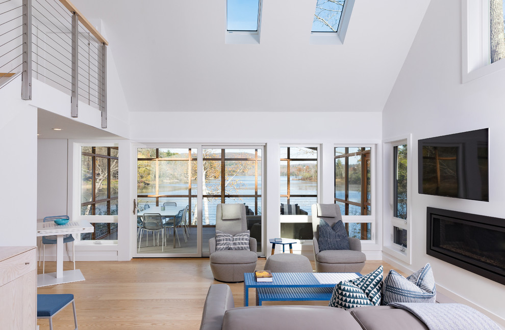 Offenes Modernes Wohnzimmer mit weißer Wandfarbe, hellem Holzboden, Kamin, TV-Wand und beigem Boden in Boston