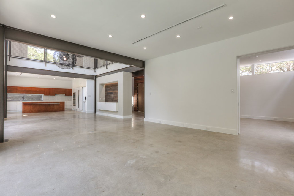 Immagine di un ampio soggiorno moderno aperto con sala formale, pareti bianche, pavimento in cemento, nessun camino, nessuna TV e pavimento grigio