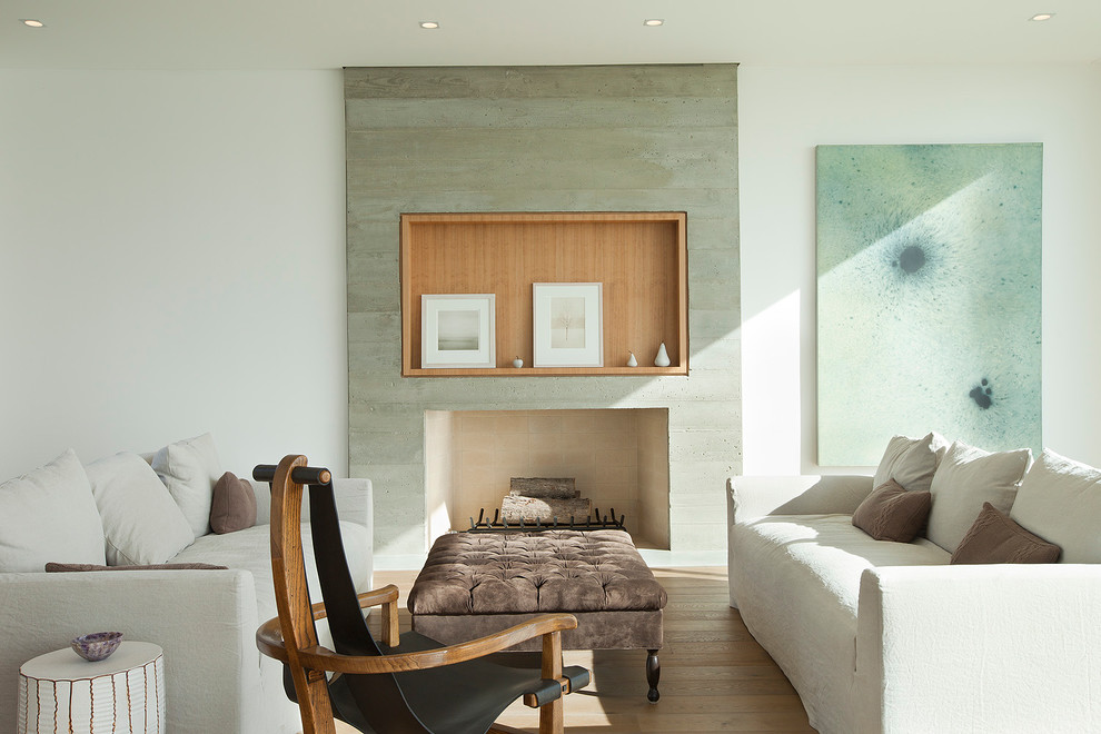 Idee per un soggiorno stile marino con sala formale, pareti bianche, pavimento in legno massello medio, camino classico e cornice del camino in cemento