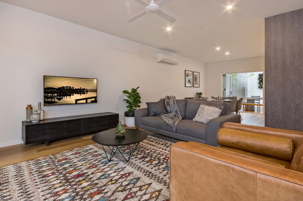 Immagine di un grande soggiorno minimal aperto con pareti bianche, pavimento in vinile e TV a parete