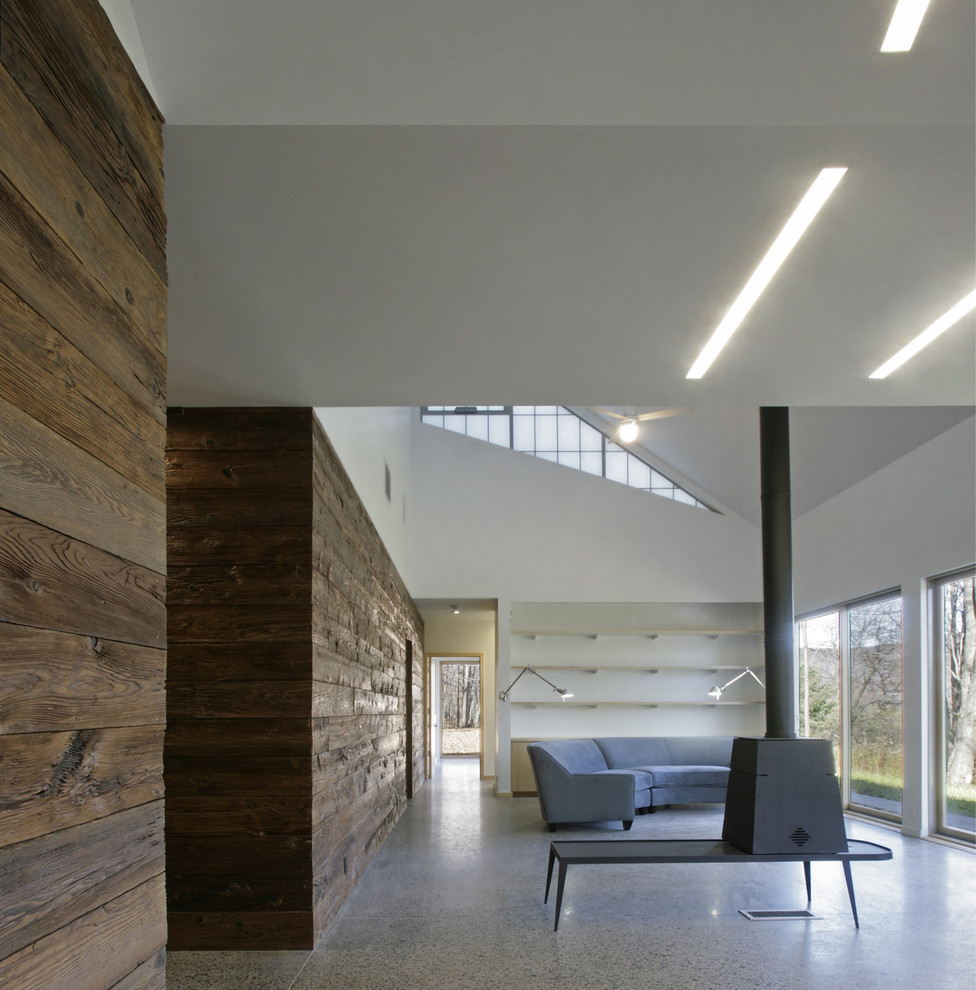 Esempio di un soggiorno minimalista di medie dimensioni e aperto con pareti bianche e stufa a legna