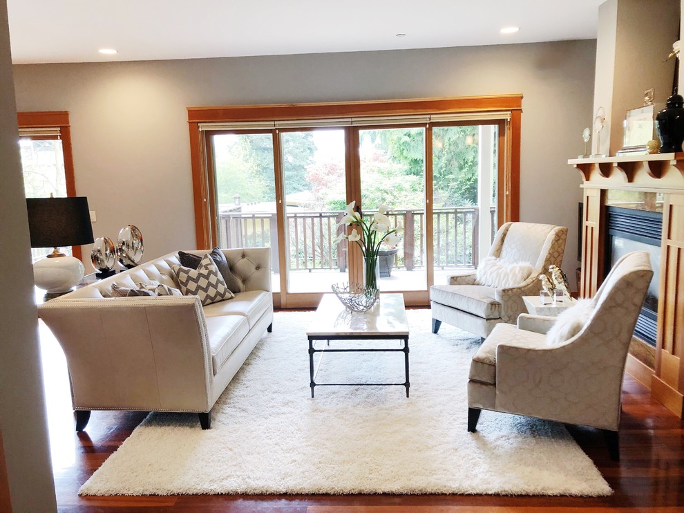 Inspiration for a small contemporary enclosed medium tone wood floor living room remodel in Seattle with gray walls, a standard fireplace and a wood fireplace surround