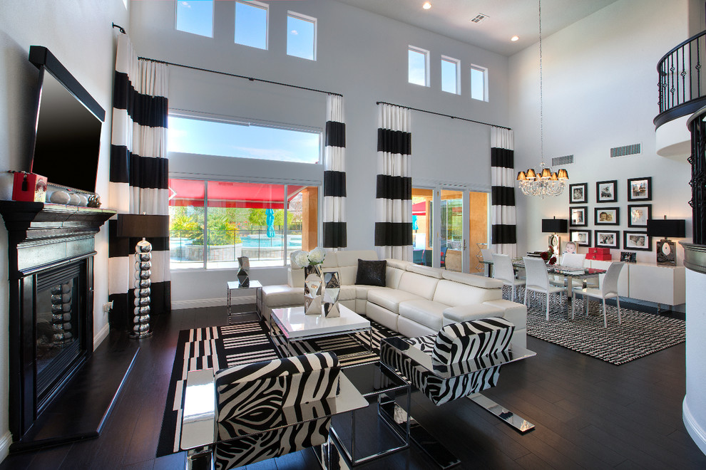 Immagine di un grande soggiorno contemporaneo aperto con pareti bianche, parquet scuro, TV a parete, camino classico e pavimento nero