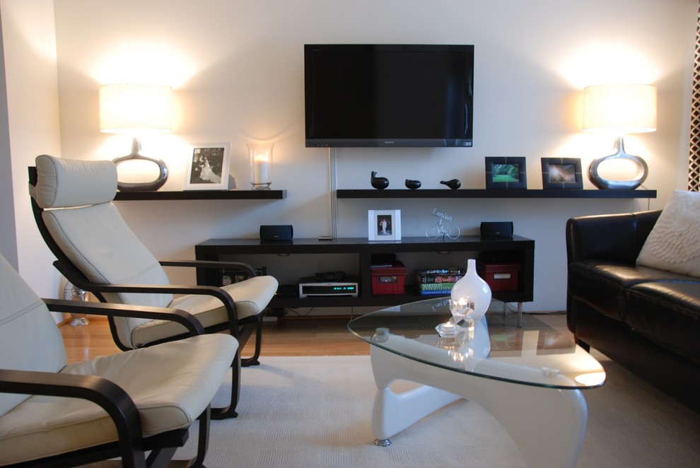 Стильный дизайн: открытая гостиная комната среднего размера в современном стиле с белыми стенами, паркетным полом среднего тона и телевизором на стене - последний тренд
