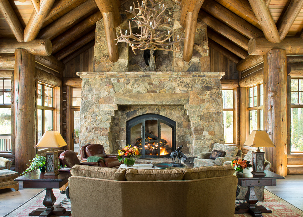 This is an example of a large rustic formal open plan living room in Denver with brown walls, dark hardwood flooring, a standard fireplace, a stone fireplace surround and no tv.
