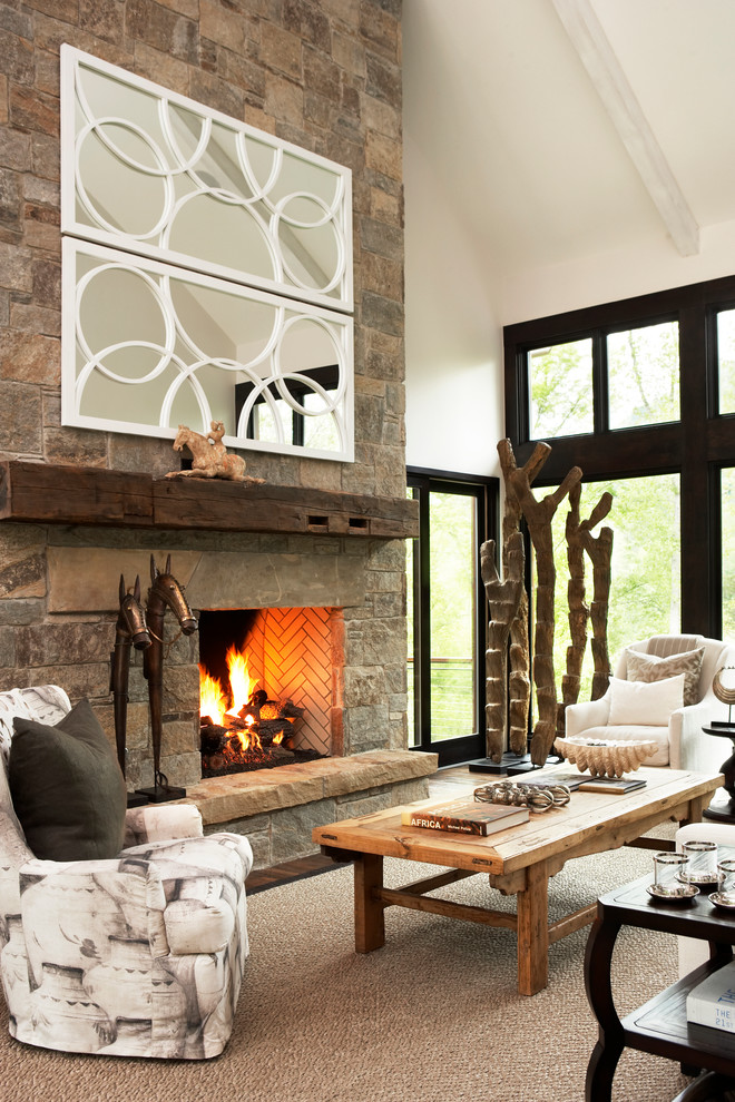 Cette image montre un salon chalet ouvert avec un mur blanc, parquet foncé, une cheminée standard, un manteau de cheminée en pierre et un téléviseur dissimulé.