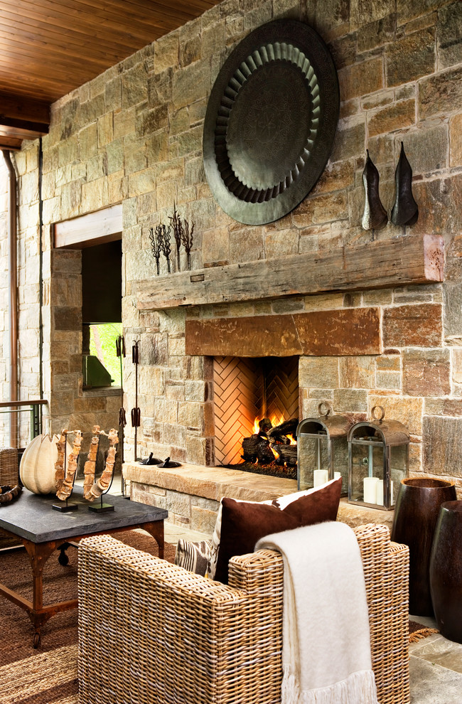 Mountain style formal living room photo in Other with a stone fireplace