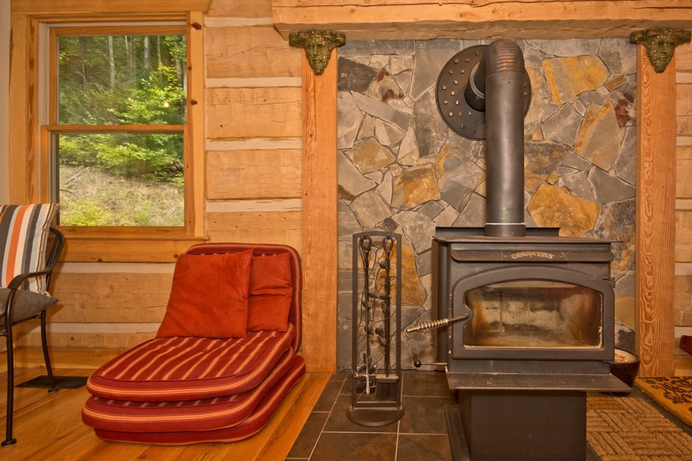 Exemple d'un petit salon montagne ouvert avec un mur beige, un sol en bois brun, un poêle à bois et aucun téléviseur.