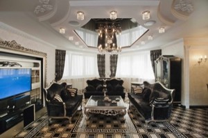 Esempio di un grande soggiorno tradizionale aperto con sala della musica, pareti beige, pavimento con piastrelle in ceramica, parete attrezzata e pavimento nero