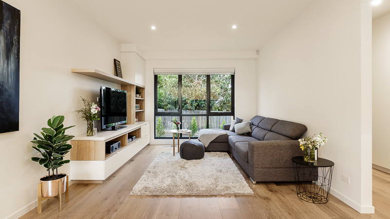 Inspiration for a medium sized scandinavian open plan living room in Melbourne with white walls, light hardwood flooring, a freestanding tv and no fireplace.