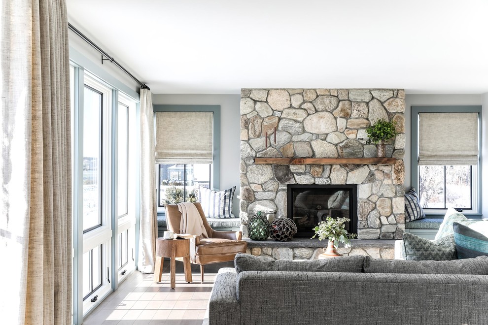 На фото: открытая гостиная комната среднего размера в морском стиле с серыми стенами, паркетным полом среднего тона, стандартным камином и фасадом камина из камня
