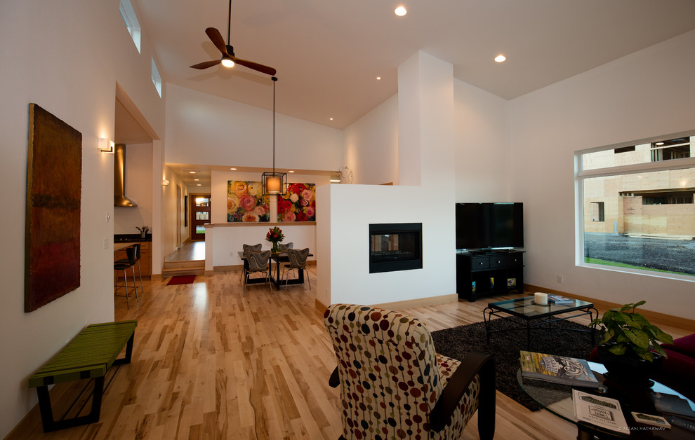 Imagen de salón minimalista con paredes blancas, suelo de madera clara y chimenea de doble cara