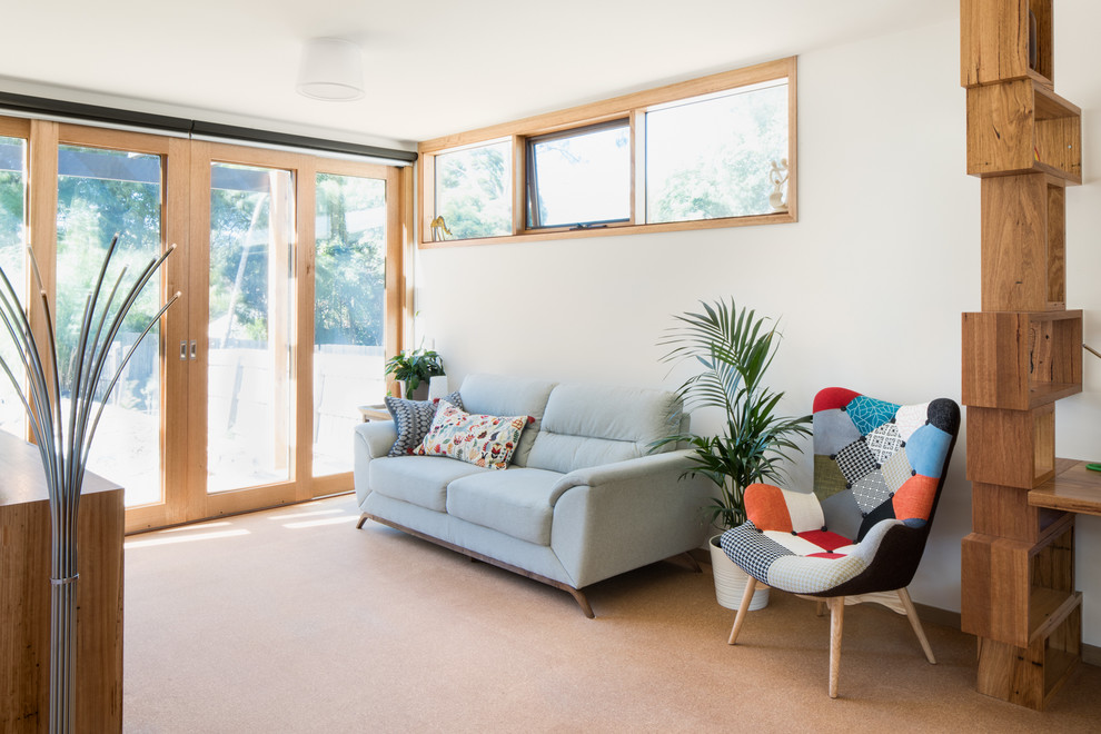 Kleines, Fernseherloses, Offenes Mid-Century Wohnzimmer ohne Kamin mit weißer Wandfarbe, Korkboden und braunem Boden in Melbourne