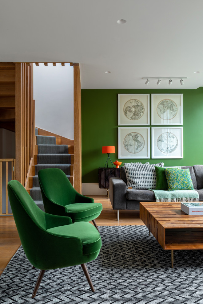 Großes, Offenes Modernes Wohnzimmer mit grüner Wandfarbe, hellem Holzboden und TV-Wand in London