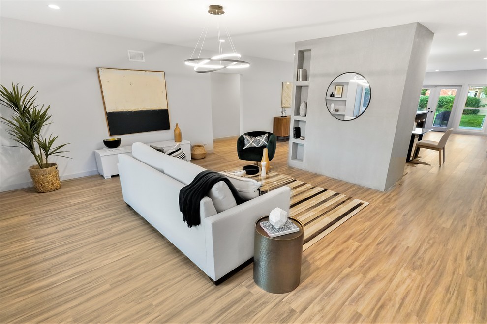 Cette photo montre un salon tendance ouvert avec un mur gris, aucun téléviseur, un sol en vinyl, une cheminée standard, un manteau de cheminée en béton et un sol multicolore.