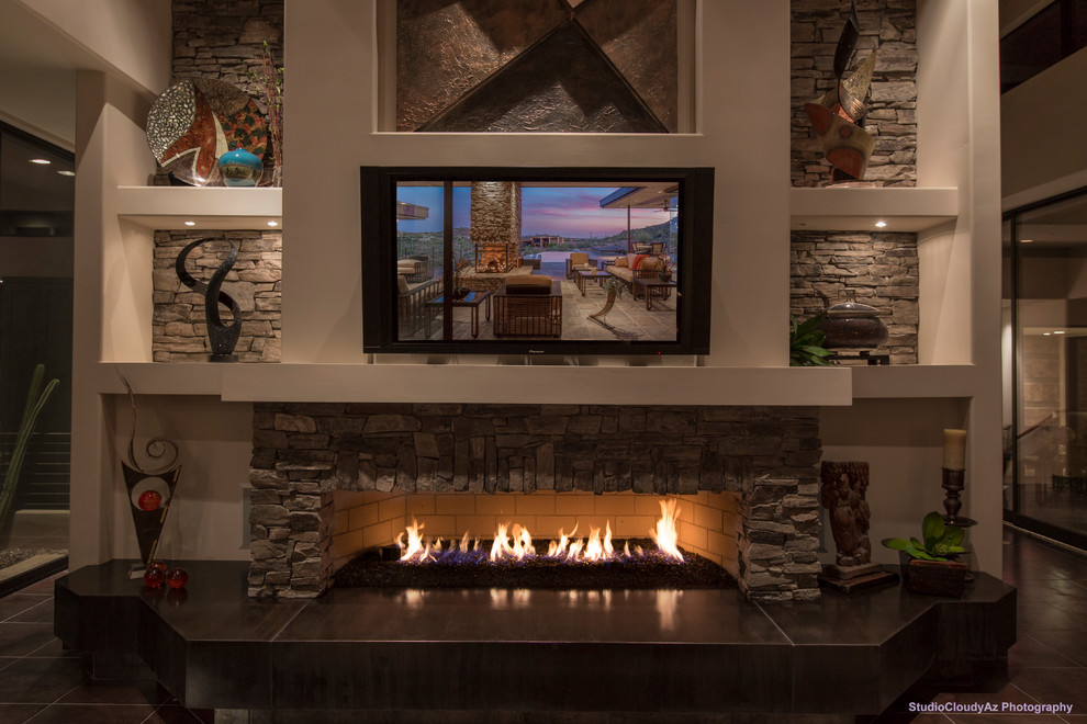フェニックスにある高級な広いコンテンポラリースタイルのおしゃれなLDK (ベージュの壁、セラミックタイルの床、横長型暖炉、石材の暖炉まわり、壁掛け型テレビ) の写真
