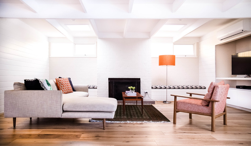 Mittelgroßes, Offenes Modernes Wohnzimmer mit Hausbar, weißer Wandfarbe, Kamin, Kaminumrandung aus Backstein und freistehendem TV in Melbourne