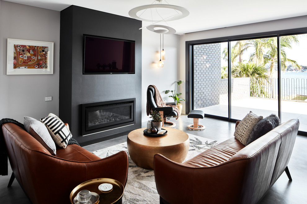 Свежая идея для дизайна: гостиная комната в современном стиле с серыми стенами, телевизором на стене, бетонным полом, горизонтальным камином и красным полом - отличное фото интерьера