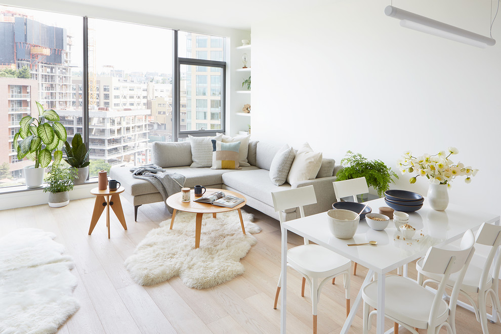 Inspiration for a small scandinavian open concept light wood floor and beige floor living room remodel in Seattle with white walls, a two-sided fireplace and a stone fireplace