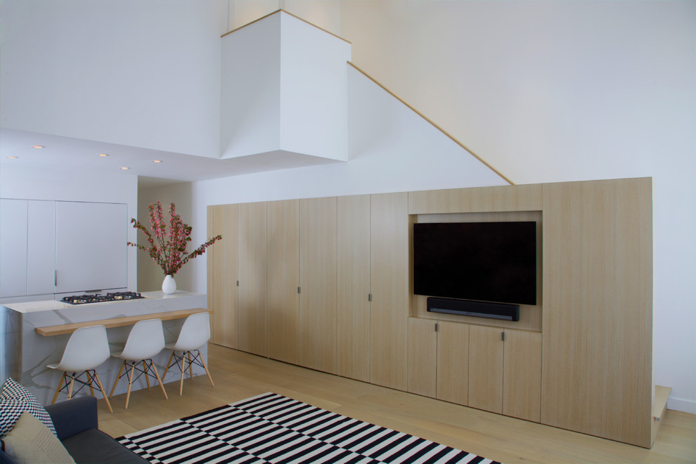 Imagen de salón para visitas abierto nórdico de tamaño medio sin chimenea con paredes blancas, suelo de madera clara, pared multimedia y suelo beige