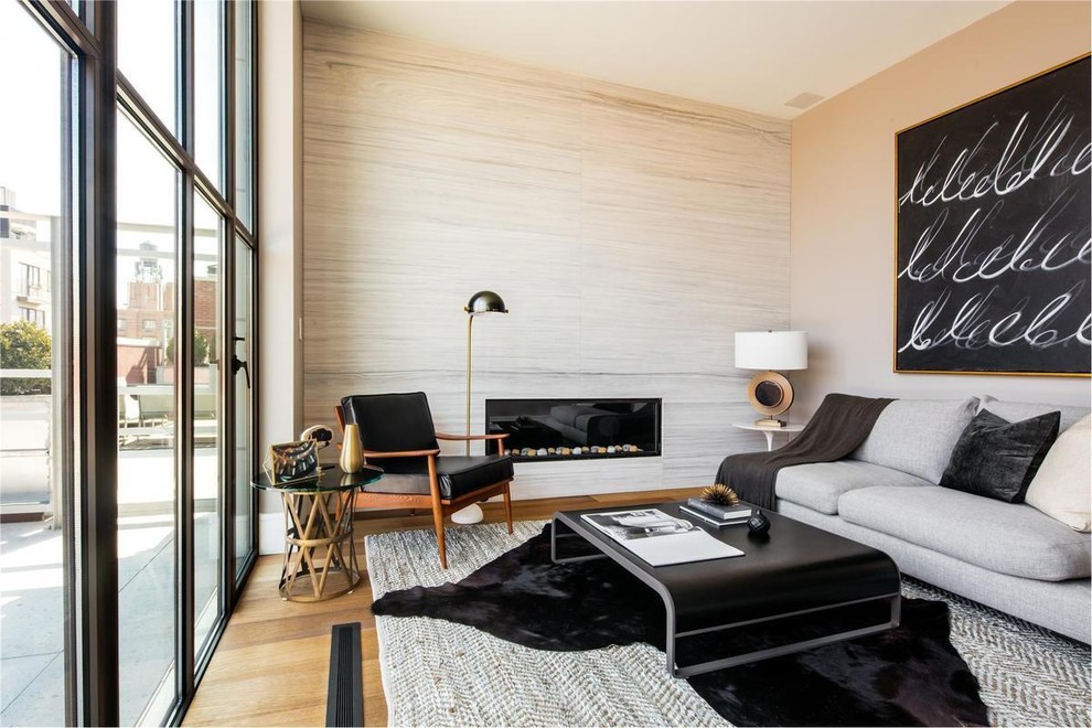 Ejemplo de salón para visitas contemporáneo de tamaño medio sin televisor con paredes beige, suelo de madera clara y chimenea lineal