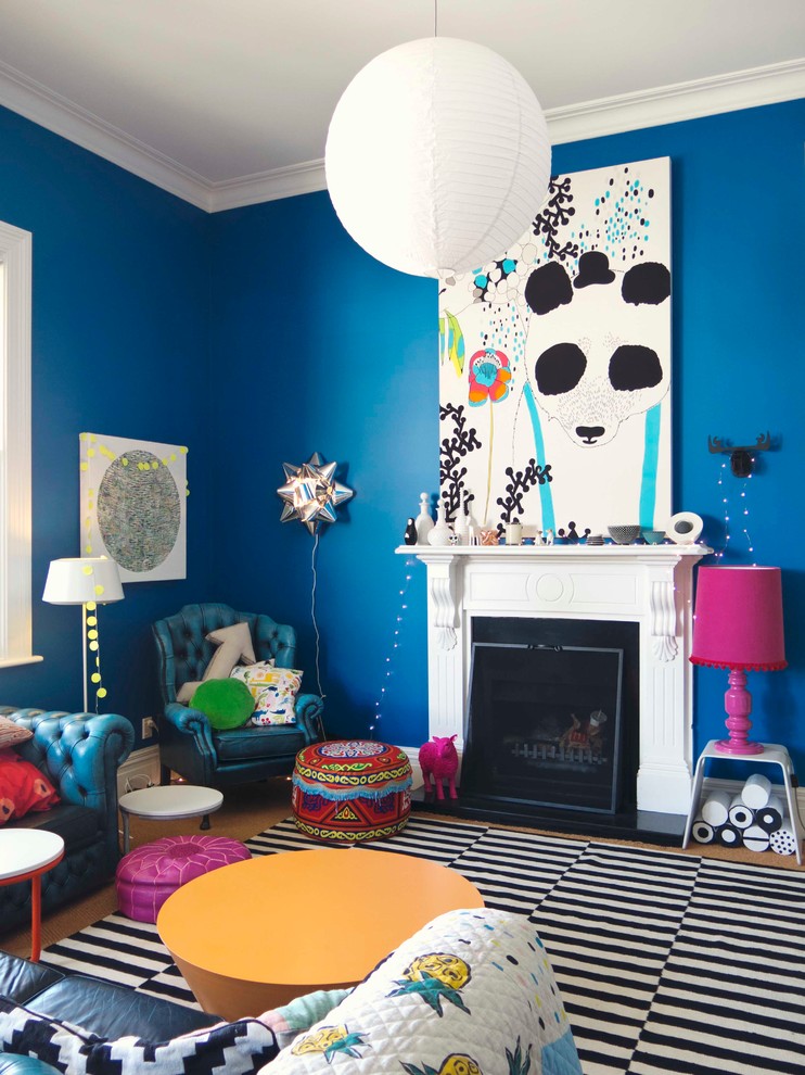 На фото: гостиная комната в стиле фьюжн с синими стенами и стандартным камином с