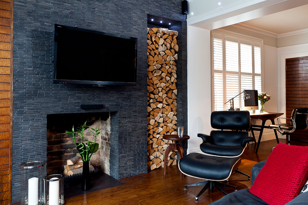 На фото: гостиная комната в стиле модернизм с стандартным камином, фасадом камина из плитки и телевизором на стене с