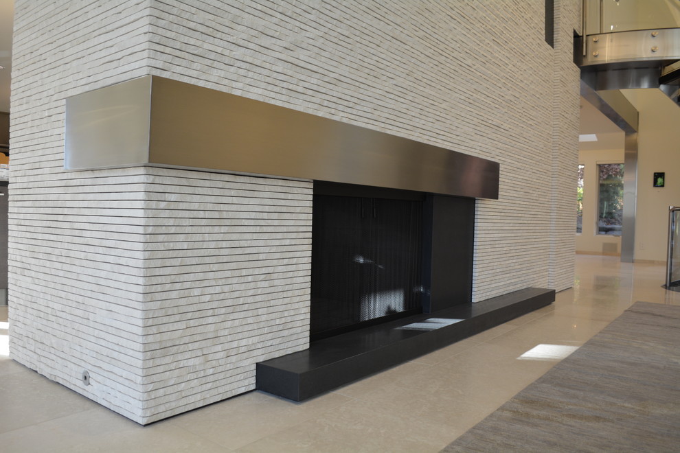 Источник вдохновения для домашнего уюта: большая открытая гостиная комната в стиле модернизм с белыми стенами, полом из керамической плитки, стандартным камином и фасадом камина из камня