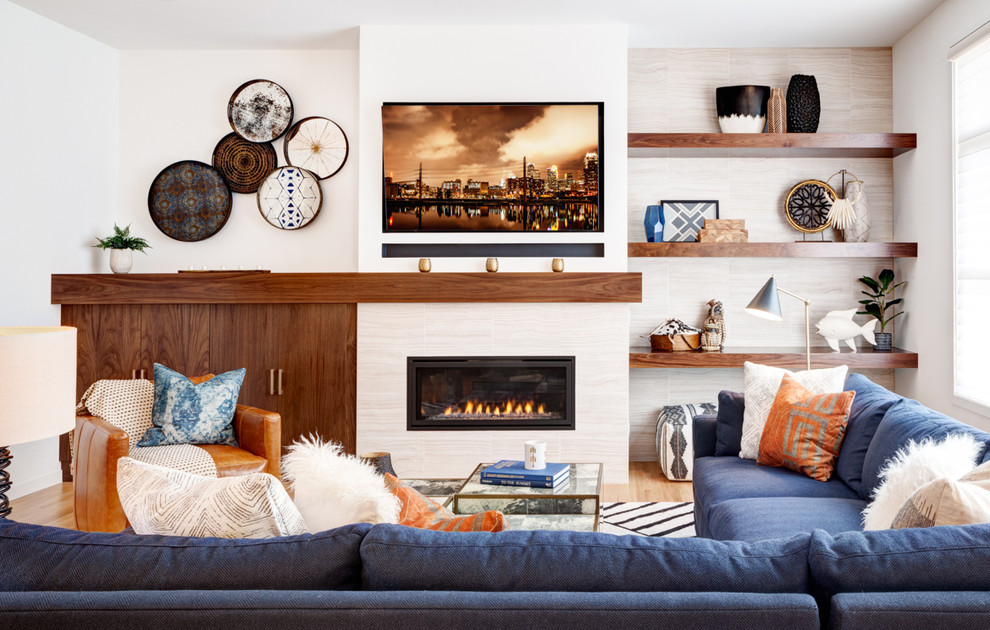 ミネアポリスにある広いトランジショナルスタイルのおしゃれなLDK (白い壁、無垢フローリング、横長型暖炉、タイルの暖炉まわり、壁掛け型テレビ) の写真