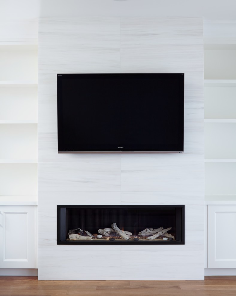 Großes, Offenes Klassisches Wohnzimmer mit weißer Wandfarbe, braunem Holzboden, Kamin, gefliester Kaminumrandung und TV-Wand in Toronto