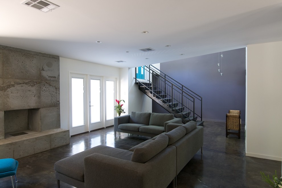 На фото: гостиная комната в современном стиле с синими стенами и фасадом камина из бетона