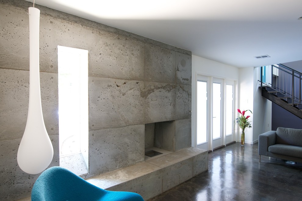 Bild på ett funkis vardagsrum, med en spiselkrans i betong och vita väggar