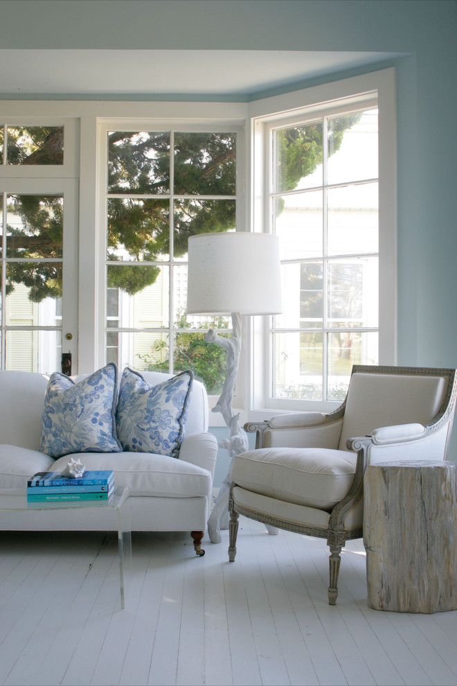 Пример оригинального дизайна: гостиная комната в морском стиле с синими стенами, деревянным полом, белым полом и эркером