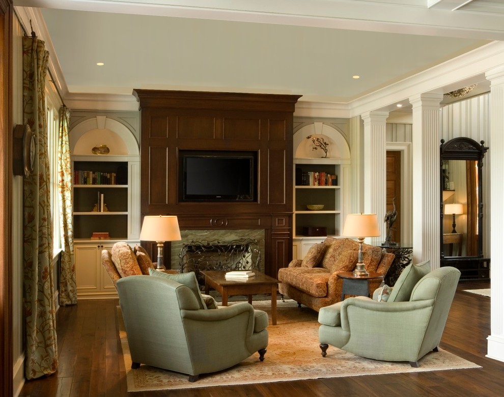 Example of a mid-sized island style dark wood floor and brown floor living room design in Charleston with beige walls, a standard fireplace, a tile fireplace and a media wall