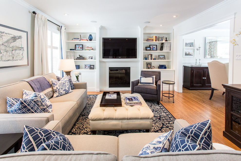 Elegant formal medium tone wood floor living room photo in Montreal with white walls, a standard fireplace and a wall-mounted tv