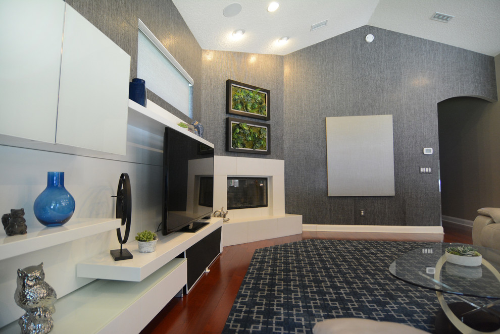 Foto på ett mellanstort funkis separat vardagsrum, med grå väggar, mörkt trägolv, en öppen hörnspis, en spiselkrans i gips och en fristående TV