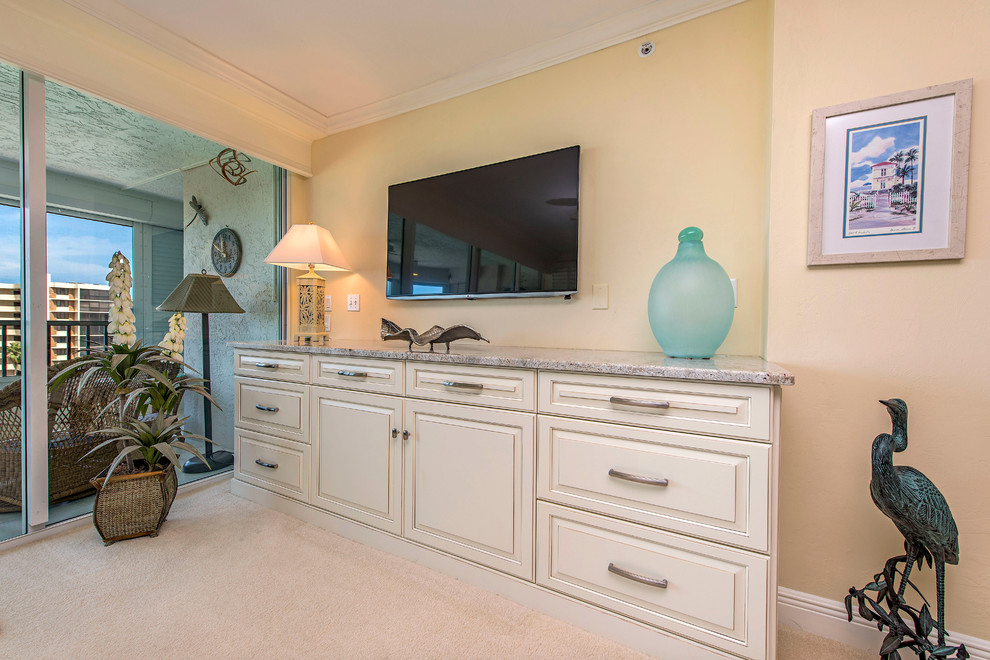 Immagine di un soggiorno chic di medie dimensioni e aperto con pareti beige, moquette, nessun camino e TV a parete