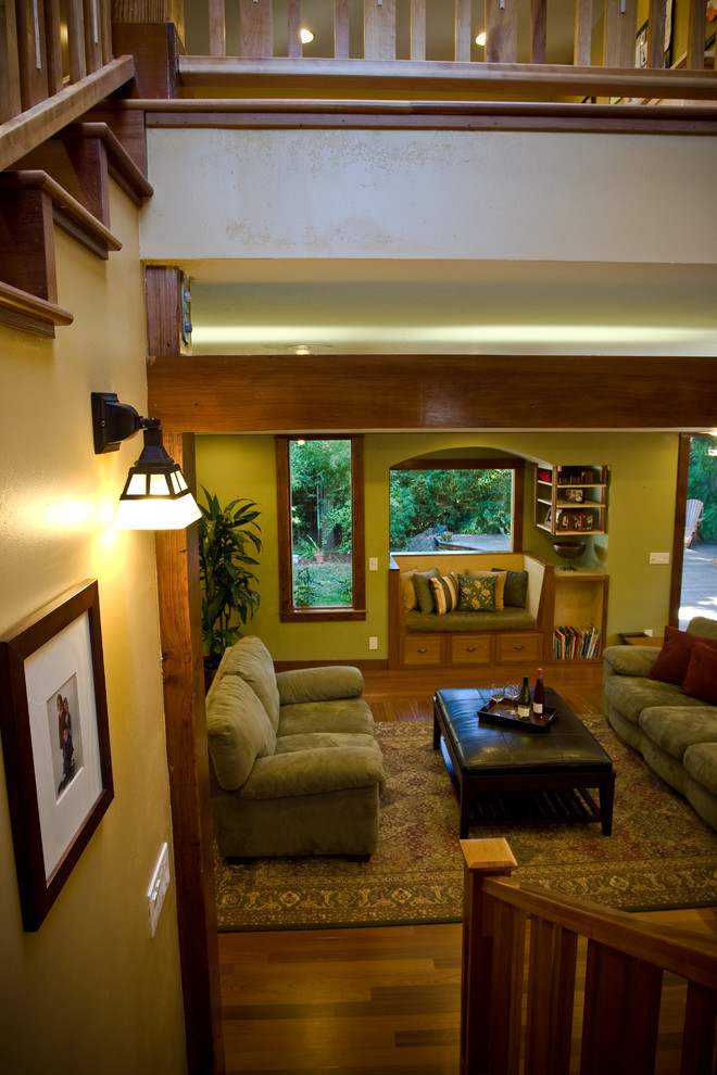 Modelo de salón abierto de estilo americano de tamaño medio sin chimenea con paredes verdes y suelo de madera clara