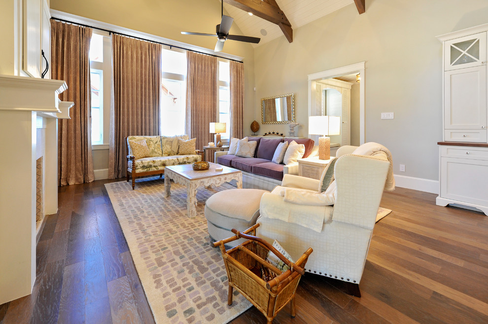 Photo of a country open plan living room in Houston with a standard fireplace, a wooden fireplace surround, a concealed tv and exposed beams.