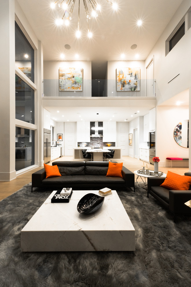 Imagen de salón abierto moderno grande sin televisor con paredes blancas, todas las chimeneas, suelo de madera clara y suelo beige