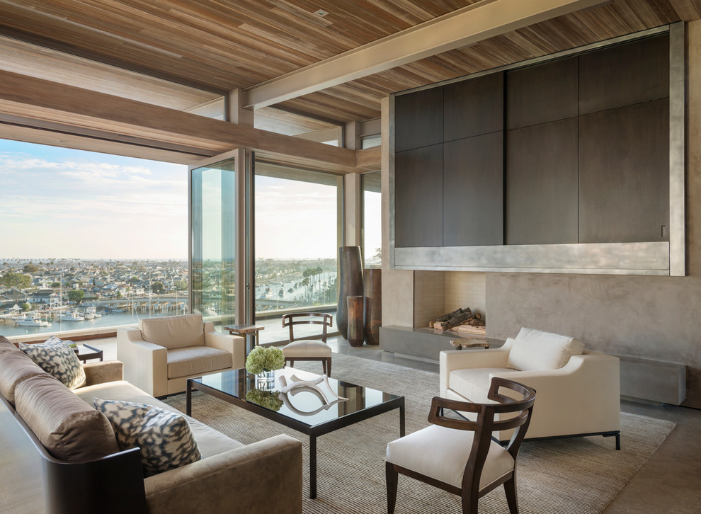 Modernes Wohnzimmer mit Kaminumrandung aus Beton und Betonboden in Orange County