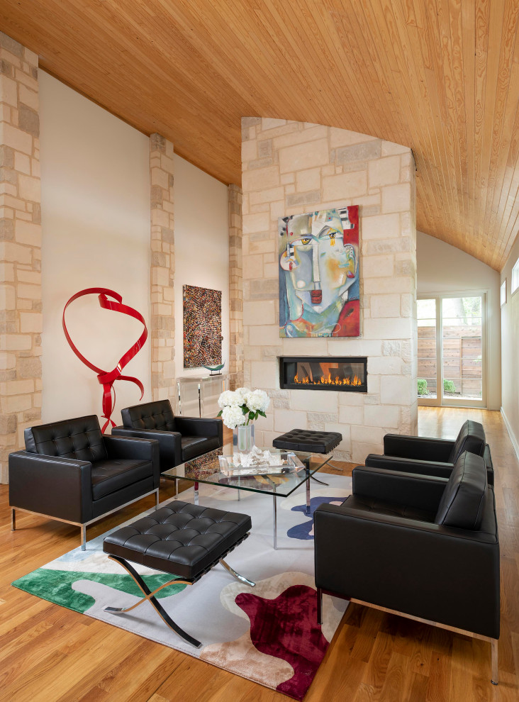 Diseño de salón abierto y abovedado de estilo americano de tamaño medio con paredes blancas, suelo de madera en tonos medios, chimenea lineal, suelo marrón, madera y marco de chimenea de piedra