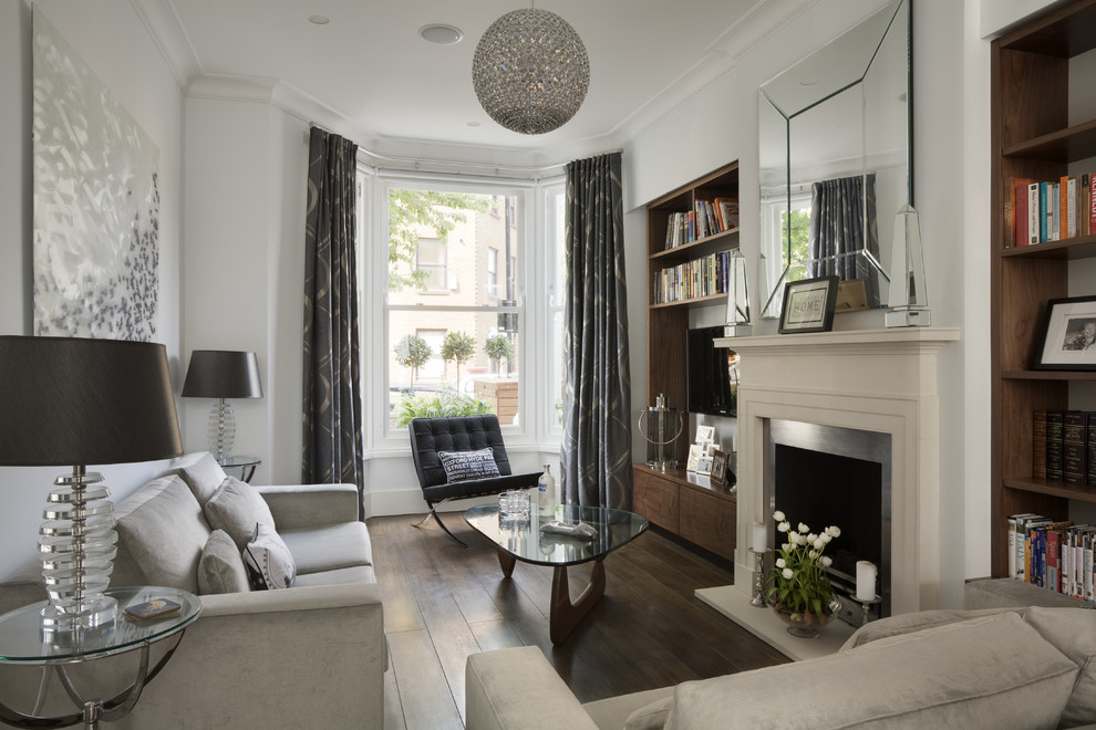 Small traditional formal enclosed living room in London with white walls, dark hardwood flooring, a standard fireplace, a metal fireplace surround and a wall mounted tv.
